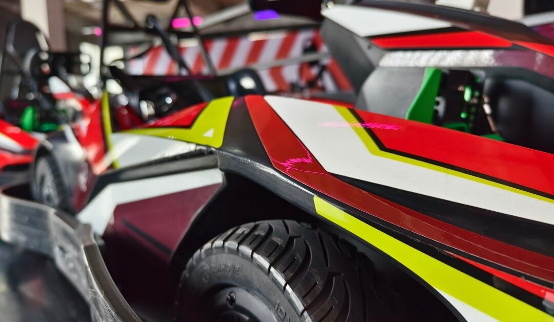 A close-up of a sleek electric go-kart with red, white, and yellow accents showcasing modern a design and racing details.